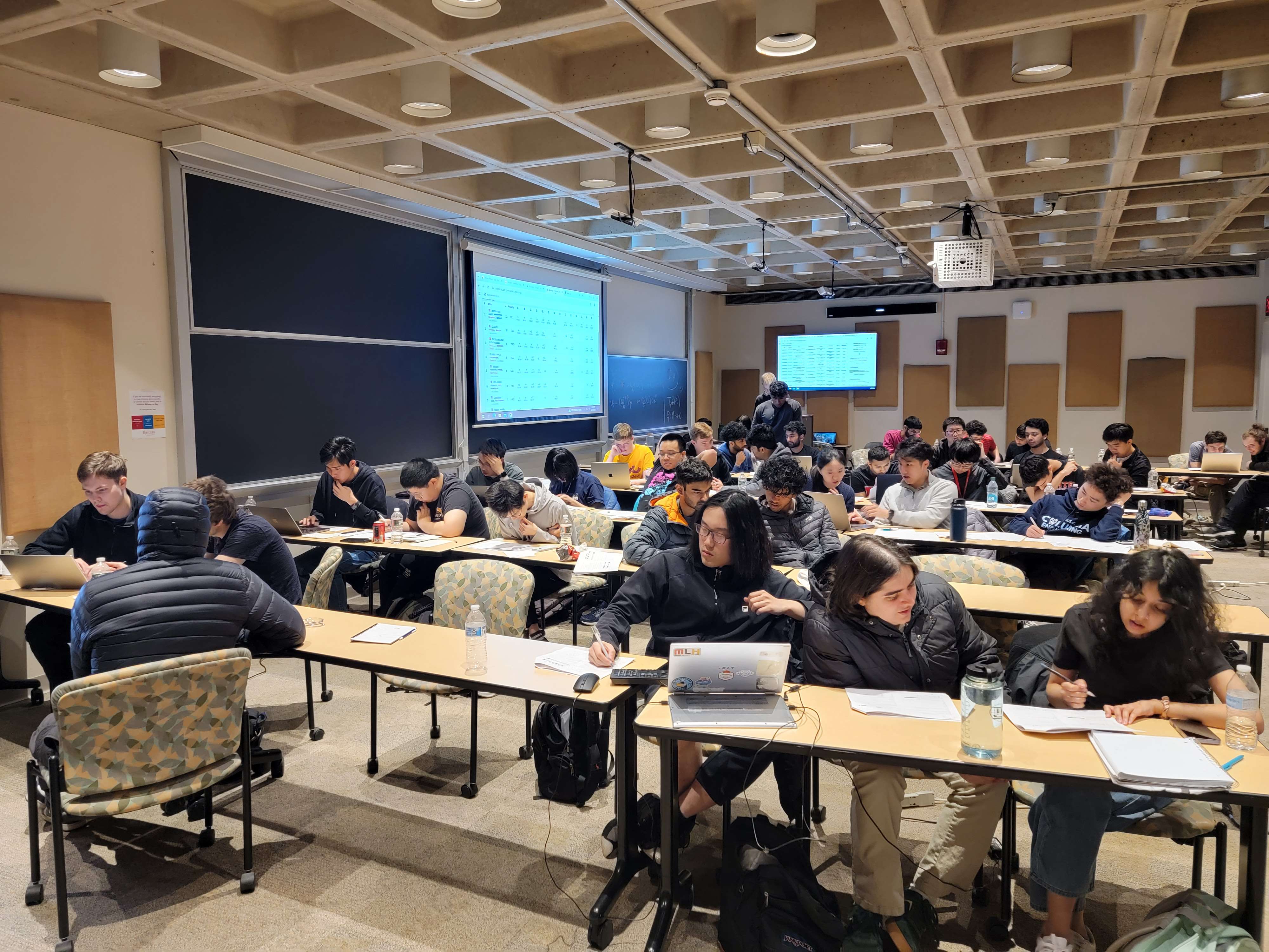 Contest participants solving problems in a lecture hall